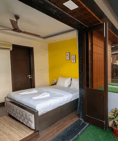 A hotel room with a balcony overlooking the metro line and urban surroundings - Lime Boutique Bed & Breakfast | Nehru Place Metro